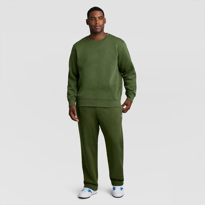 A man wearing an olive green Champion Powerblend Crewneck Sweatshirt, C Logo - Big & Tall and matching sweatpants.