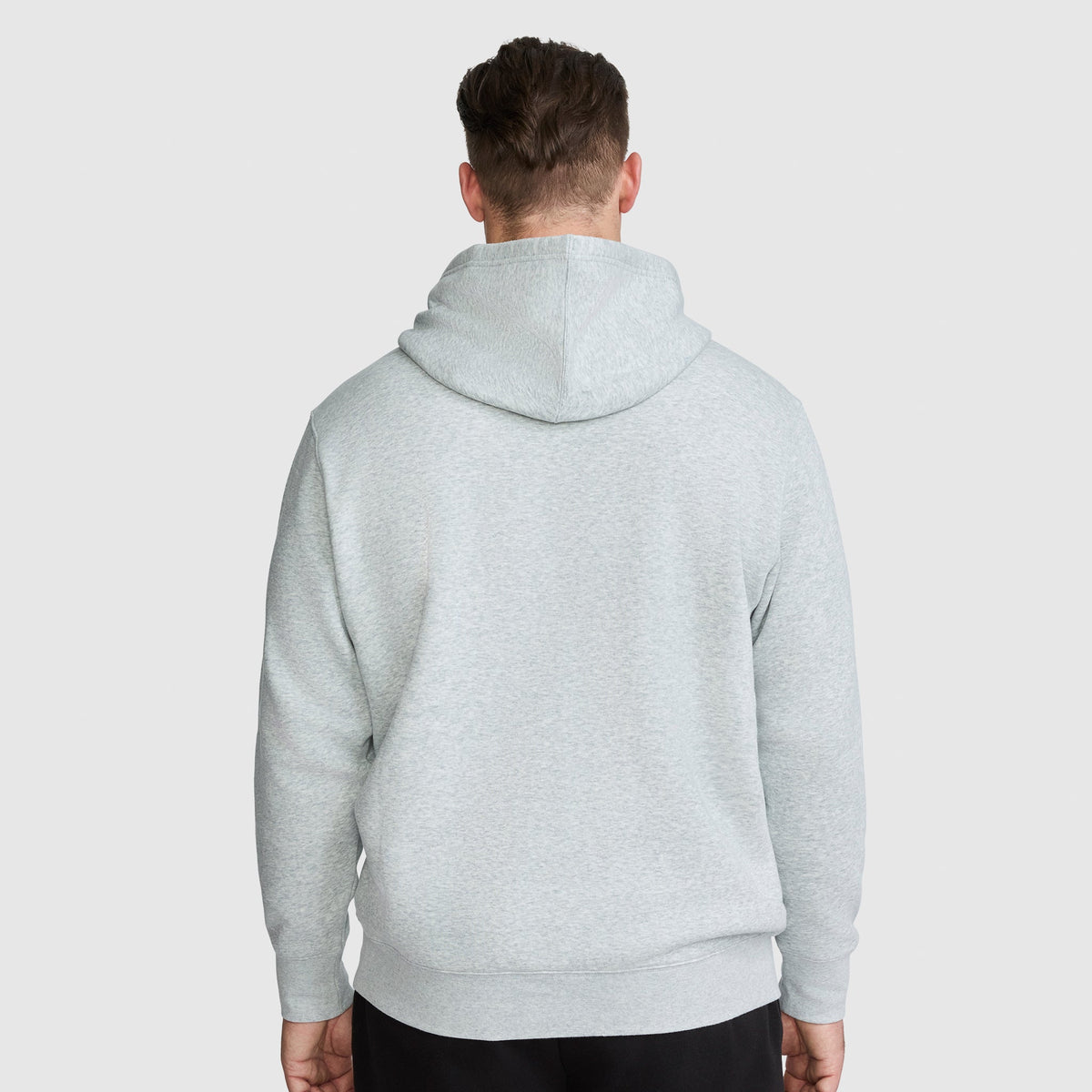 A man seen from behind wearing a light gray Champion Powerblend Hoodie, Full Script Logo - Big & Tall.