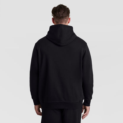 A person seen from behind wearing a black Champion Powerblend Hoodie, Full Script Logo - Big & Tall.