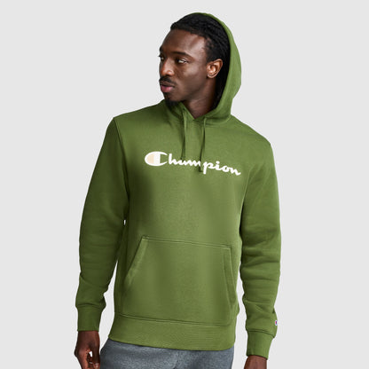 A man wearing a green Champion Powerblend Hoodie, Full Script Logo, featuring a front pocket and hood, looks to his left against a plain light gray background.