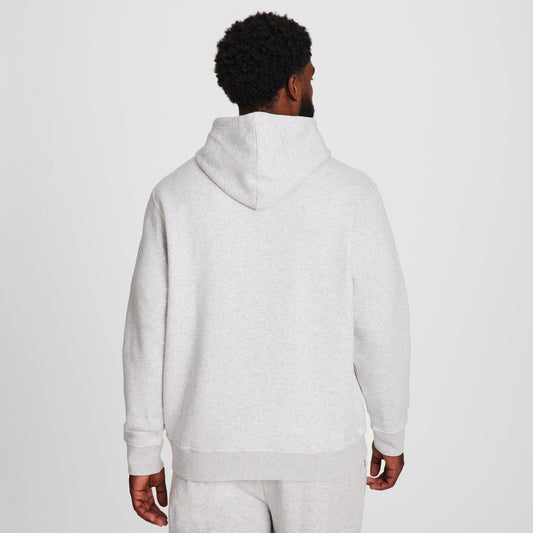 A man faces away from the camera, wearing a light gray Champion Powerblend Hoodie, C Logo - Big & Tall with matching sweatpants against a plain white background.