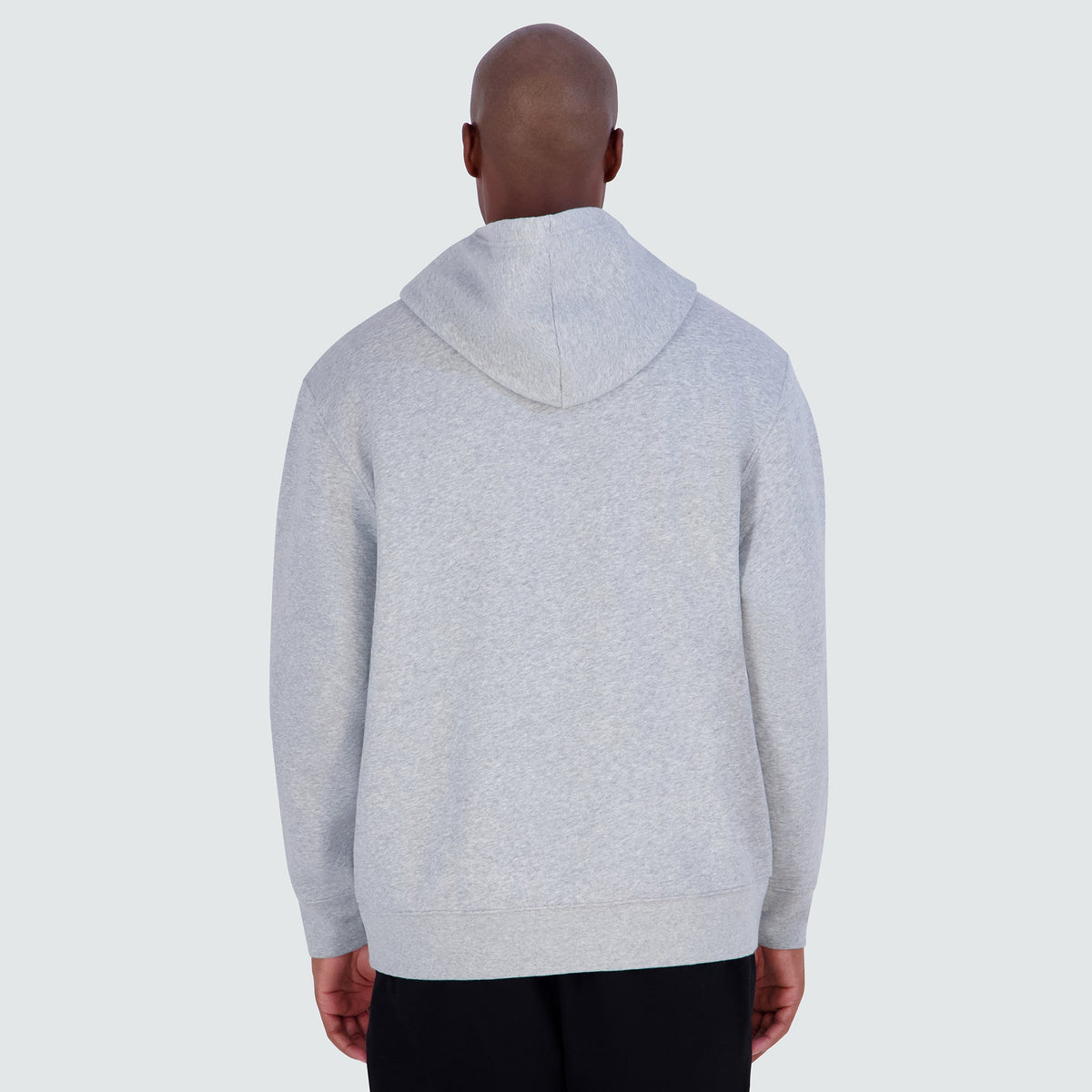 A person seen from behind wearing a light gray Champion Powerblend Hoodie, C Logo - Big & Tall.