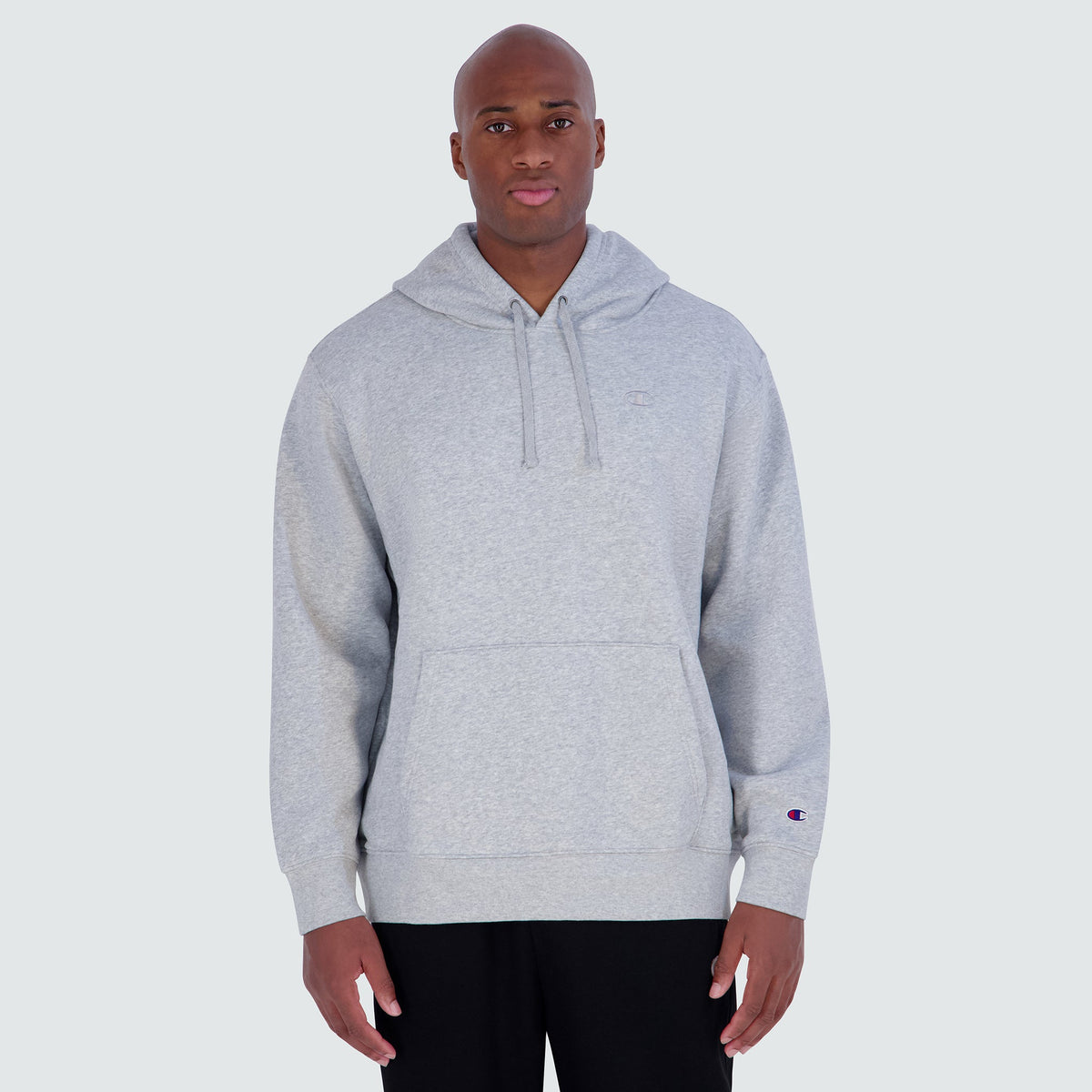 A grey Champion Powerblend Hoodie, C Logo - Big & Tall featuring a front kangaroo pocket and a small logo on the chest and left sleeve.