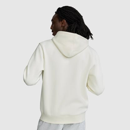 A person with long, dark hair is seen from behind wearing a white Champion Powerblend Hoodie with the C Logo, standing against a plain light background.