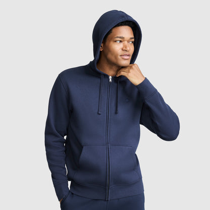 A person wearing a navy blue Powerblend Full-Zip Hoodie, C Logo with the hood up.