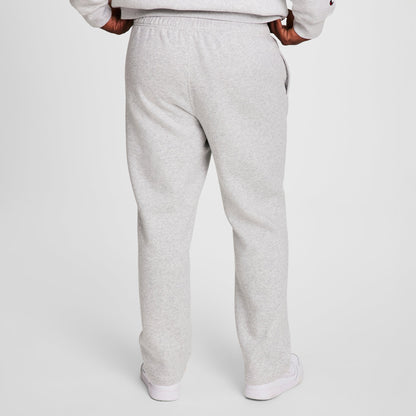 A person stands facing away against a white background, wearing Champion Powerblend Sweatpants, Open Hem, C Logo - Big & Tall in light gray with a matching sweatshirt and white sneakers. Hands are on hips.