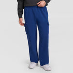 A person is wearing Champion’s Fleece Cargo Pant, C Logo in blue, paired with a dark gray sweatshirt and white sneakers, standing against a light gray background. Only the lower half of the body is visible, highlighting these stylish men’s streetwear pants from Champion.