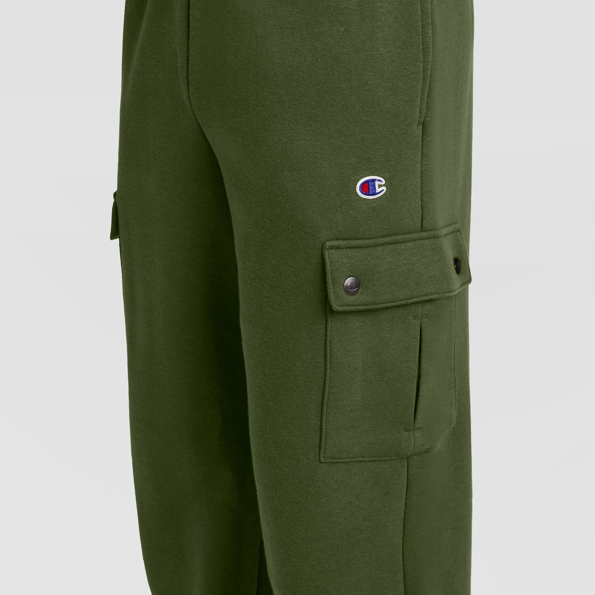 Close-up of Champion Fleece Cargo Pant, C Logo in green streetwear style, featuring a small C logo on the thigh and a buttoned side pocket—blending classic Champion design with modern comfort and style.