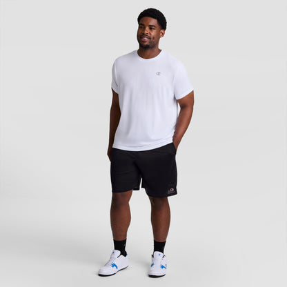 A man wearing a white t-shirt, 9″ Classic Mesh Shorts, C Logo - Big & Tall, and white athletic shoes.