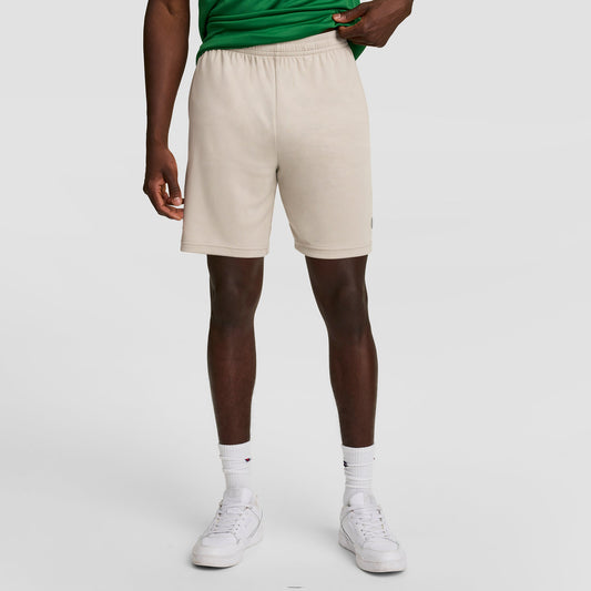 A person in a green shirt, Champion 7" Moisture Wicking Sport Shorts, white crew socks, and white sneakers stands against a plain light background. Their face is not visible.