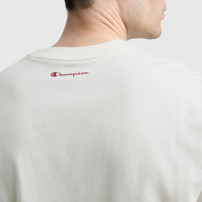 A close-up of the back of a person wearing an off-white Champion Classic Graphic T-Shirt, Script Logo, featuring streetwear style with the iconic red Champion logo near the neckline.