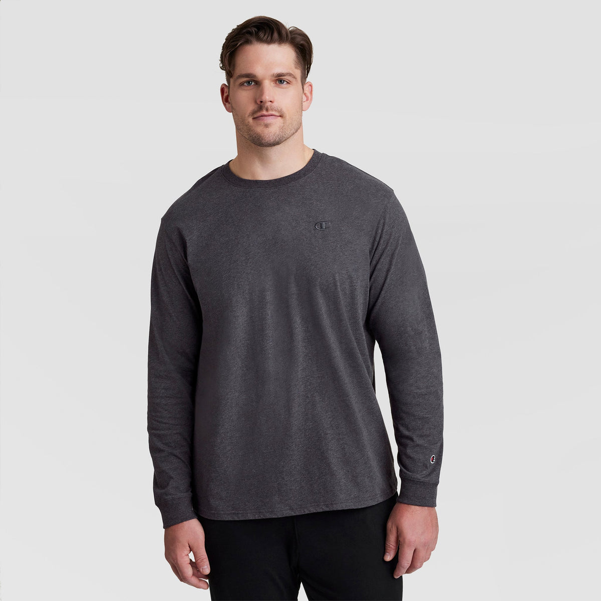 A man wearing a charcoal grey Classic Long Sleeve T-Shirt, Embroidered C Logo - Big & Tall with a small logo embroidered on the chest and cuff.