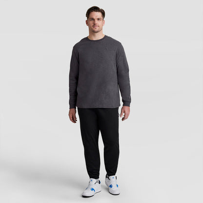 A man wearing a charcoal Classic Long Sleeve T-Shirt, Embroidered C Logo - Big & Tall, black sweatpants, and white sneakers.