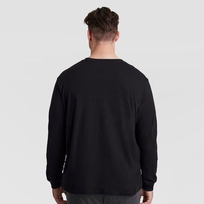 Back view of a person wearing a plain black Classic Long Sleeve T-Shirt, Embroidered C Logo - Big & Tall from Champion.