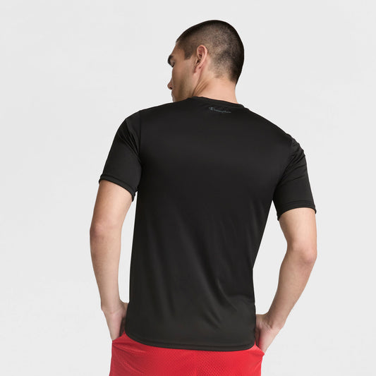 A man wearing a black Champion Sport T-Shirt with Reflective C Logo and red shorts stands facing away, hands on hips, against a plain white background.