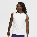 A man with long braided hair wears the Champion Sport Muscle Tank with Reflective C Logo and blue shorts, looking to his left against a plain white background.