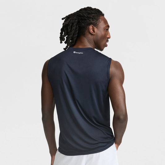 A man with long, braided hair is seen from the back wearing Champion’s Sport Muscle Tank with a reflective C logo, paired with white shorts, set against a plain white background—an ideal men’s workout top.