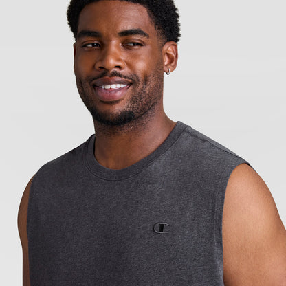 A man with short curly hair, a trimmed beard, and a small hoop earring smiles while wearing the Champion Muscle Tank, C Logo - Big & Tall in dark gray against a plain light gray background.