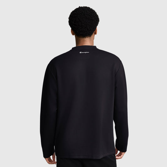 A person stands facing away, wearing a black Champion Sport Long Sleeve Crewneck, C Logo, with the brand's logo featured at the top center of the back against a plain gray background—ideal athletic wear that combines performance and style.