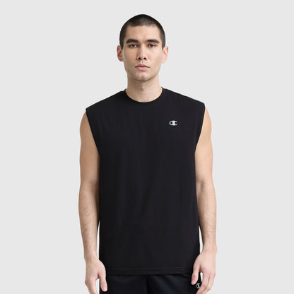 A man with short dark hair wears a black Champion Sport Crewneck Muscle Tee with script logo and black shorts, standing against a plain light gray background.