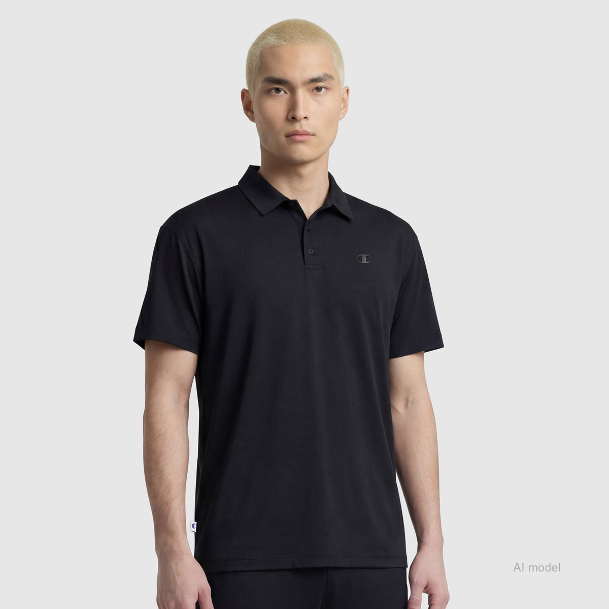 A person with short, bleached blond hair wears the Champion Sport Polo with C Logo, featuring four-way stretch, while standing against a plain light gray background.