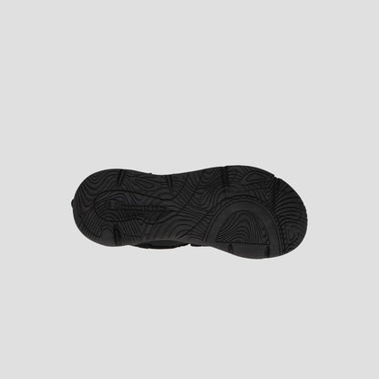 Men's Hyper C Pilot W by Champion: black lifestyle sneaker with wavy, textured sole for traction, durable mesh upper, and Champion-branded toggle. Photographed against a plain light gray background.