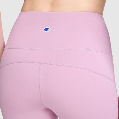 Close-up of a person wearing Champion Soft Touch Flare Leggings for women in light purple, featuring a high-waisted design with visible seam details and the signature C logo on the waistband.