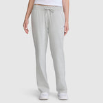 A person wearing Champion Lightweight Lounge Pants, C Logo in light gray, along with a white shirt and white sneakers, stands against a plain white background. Only the lower torso and legs are visible.