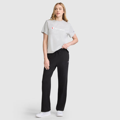 A woman wearing a gray t-shirt and Champion Lightweight Lounge Pants, C Logo, which are lightweight jersey cotton lounge pants with a drawstring waist.