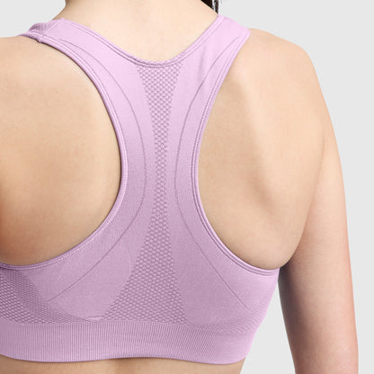 Close-up of a person’s upper back wearing the Champion Seamless Racerback Sports Bra in light purple, featuring moderate support and moisture-wicking properties, set against a plain, light gray background.