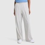 A person dressed in Champion Open Bottom Pant in a loose, light gray stretch jersey, paired with a blue top and white sneakers, stands against a plain background with only the lower half of their body visible.
