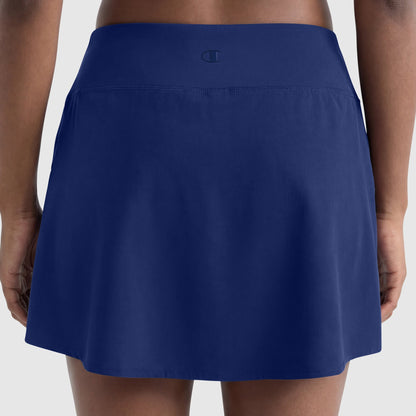 Rear view of a person wearing the Champion Courtside Skort with C Logo in navy blue, featuring a wide, smooth waistband and small logo at the center back for a polished athletic look. Hands are relaxed at their sides.