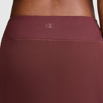 A close-up of the back waistband of the maroon Courtside Skort by Champion, featuring a subtle C logo centered near the top, highlights its sporty function for active lifestyles.