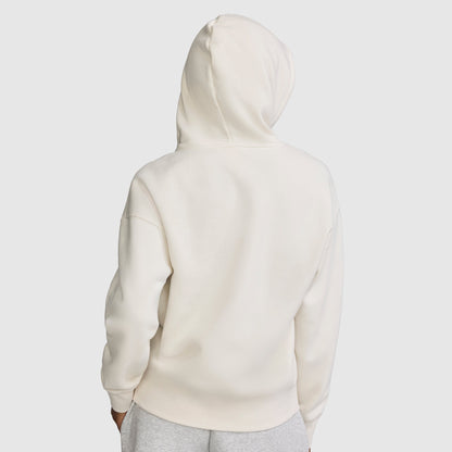A person wearing a plain white Champion Fleece Hoodie, Satin Applique, with the hood up is viewed from the back. They are also wearing light gray pants against a light gray background.