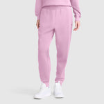 A person wearing the Champion Taper Leg Jogger with Zippers in light pink, paired with a matching pink sweatshirt and white sneakers, stands against a plain light gray background.