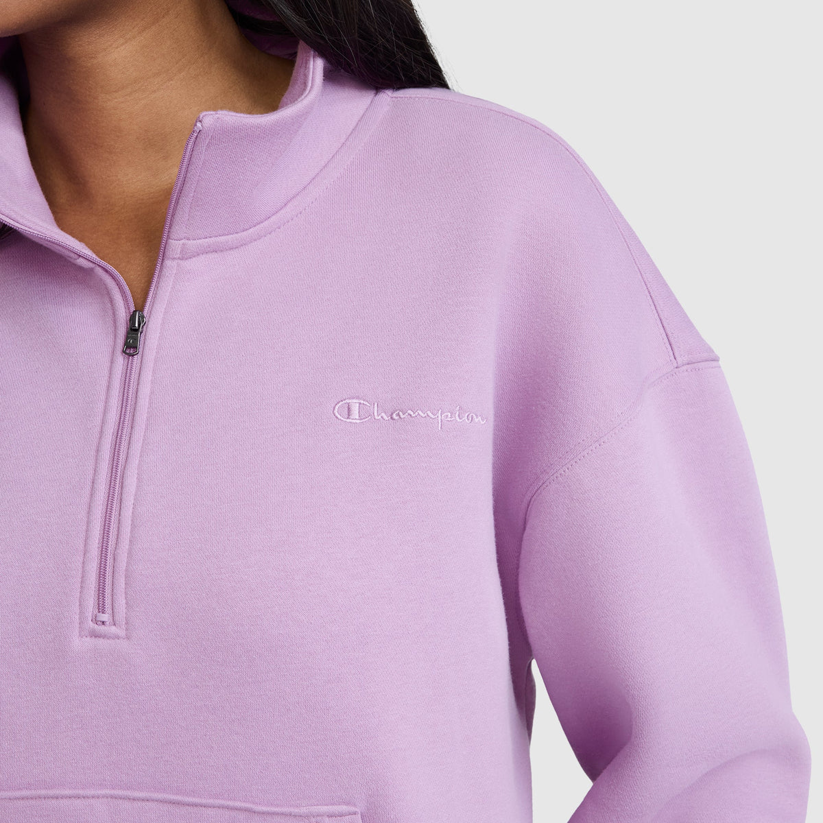 A person wearing a lavender Champion Fleece Mockneck Quarter-Zip. Only the lower face, neck, and upper torso are visible against a plain light background, emphasizing the relaxed Heritage Sport Style of this piece.