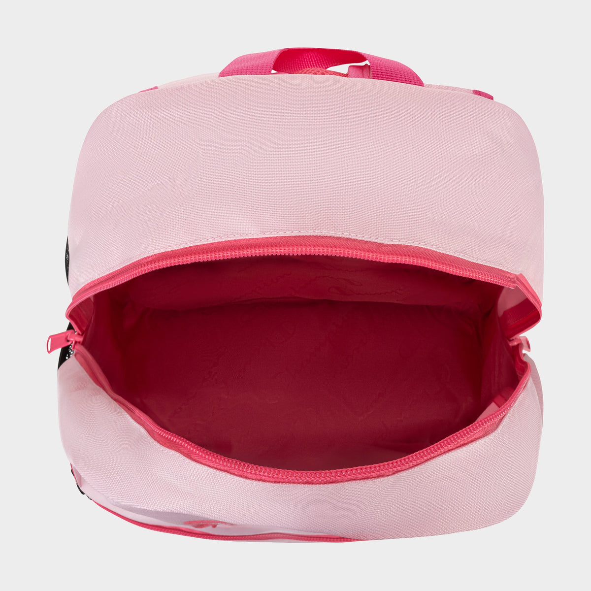 The Champion Kids' Merit Backpack is shown from above, featuring a pink design with a spacious main compartment and pink lining, displayed empty against a light background.