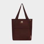The Champion Lottie Tote, presented in maroon and made from sturdy nylon, features dual straps, a convenient front zip pocket, and prominently displays the iconic Champion logo on the upper front. Photographed on a plain white background, this versatile everyday bag blends style with durability.