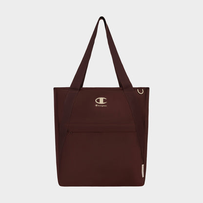 The Champion Lottie Tote, presented in maroon and made from sturdy nylon, features dual straps, a convenient front zip pocket, and prominently displays the iconic Champion logo on the upper front. Photographed on a plain white background, this versatile everyday bag blends style with durability.