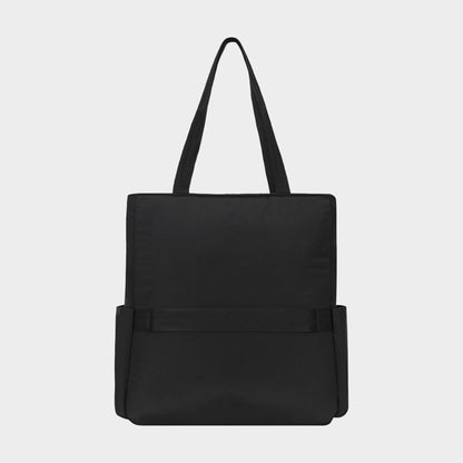 The Champion Explore Tote is a durable crinkle nylon tote bag in plain black, featuring two handles, two side pockets, and a simple rectangular silhouette, displayed against a light gray background.