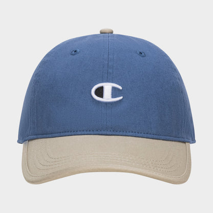 The Champion Briggs Washed Cotton Twill Adjustable Baseball Cap in blue features a beige brim and an embroidered white C logo on the front, displayed against a plain white background.