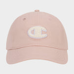 The Amber Chenille Adjustable Cap by Champion features a light pink hue, a textured white chenille patch letter C on the front, and a relaxed fit. It is shown from the front against a plain white background.