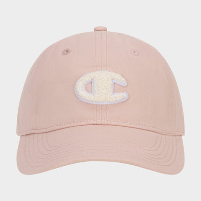 The Amber Chenille Adjustable Cap by Champion features a light pink hue, a textured white chenille patch letter C on the front, and a relaxed fit. It is shown from the front against a plain white background.