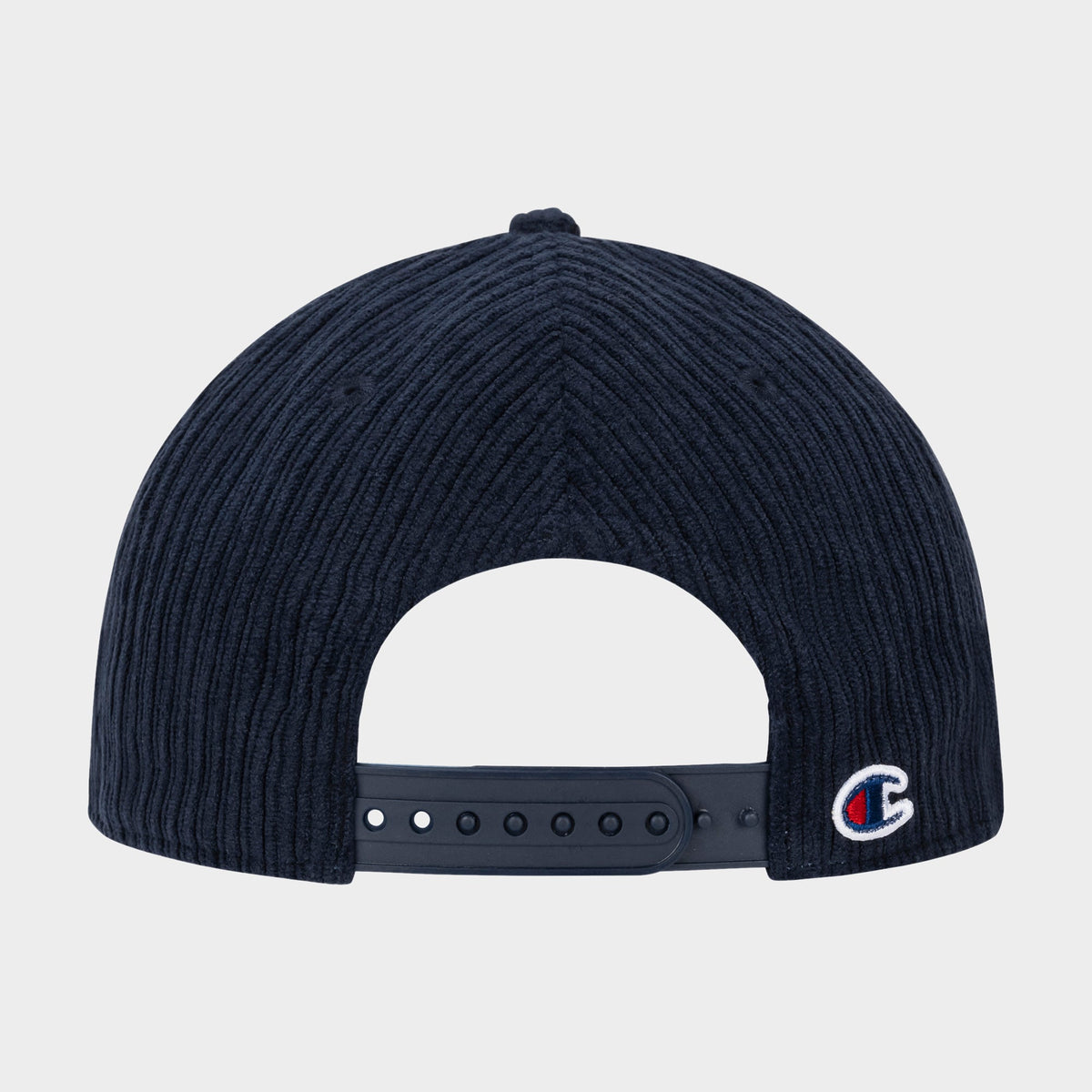 The back of the Stephen Adjustable Cap by Champion, crafted in dark blue corduroy, features an adjustable strap and a small C logo on the lower right side, showcasing the signature style of a Champion cap.