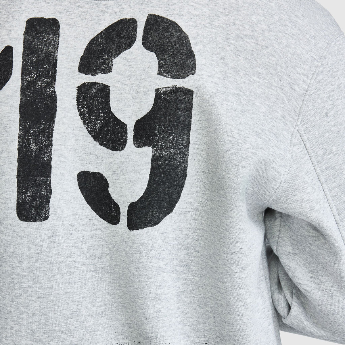 Close-up of a grey Champion Fleece Baseball Jacket with the black stencil-style number 19 printed on the back.