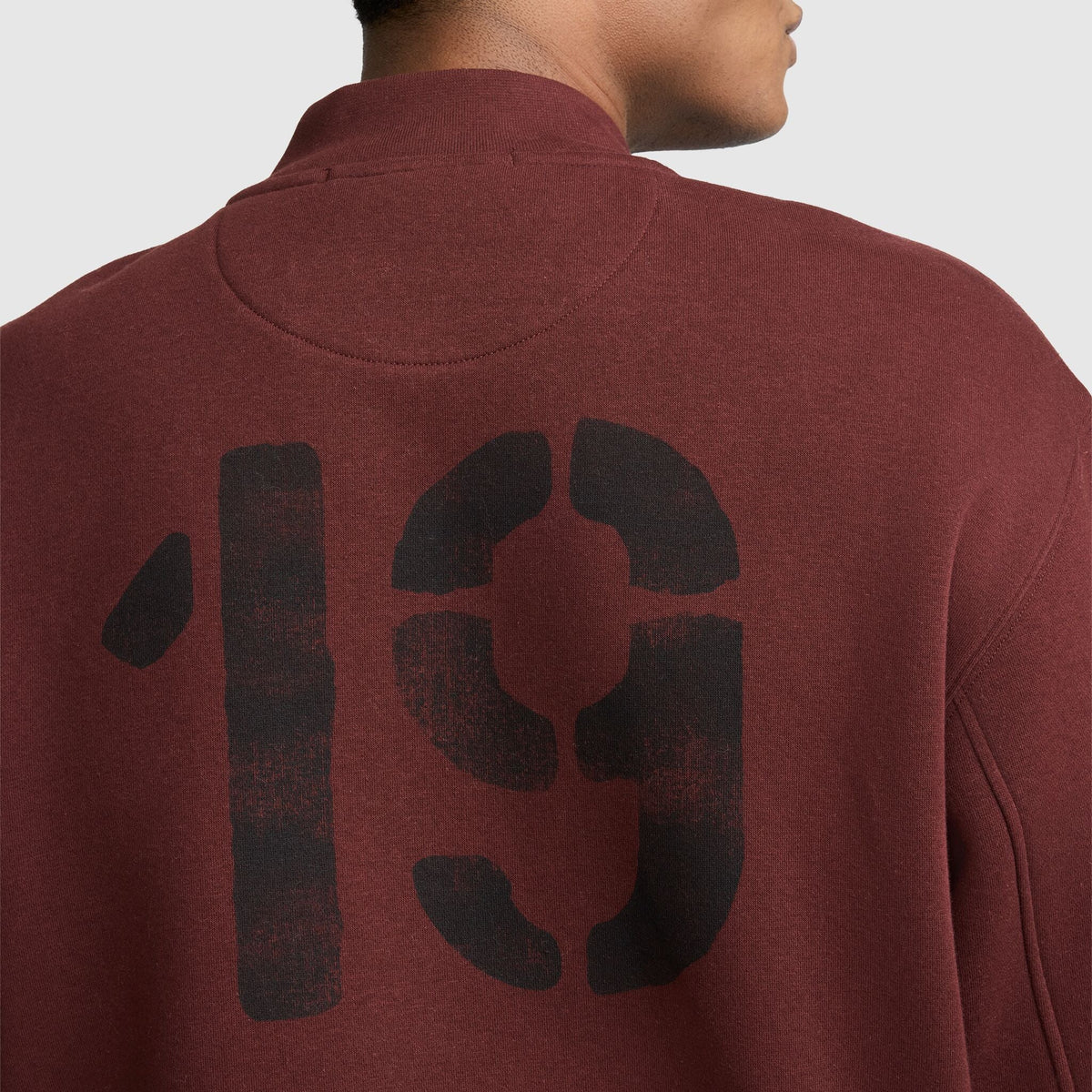 Back view of a maroon Champion Fleece Baseball Jacket featuring the number 19 printed in large black stencil-style lettering on the back.