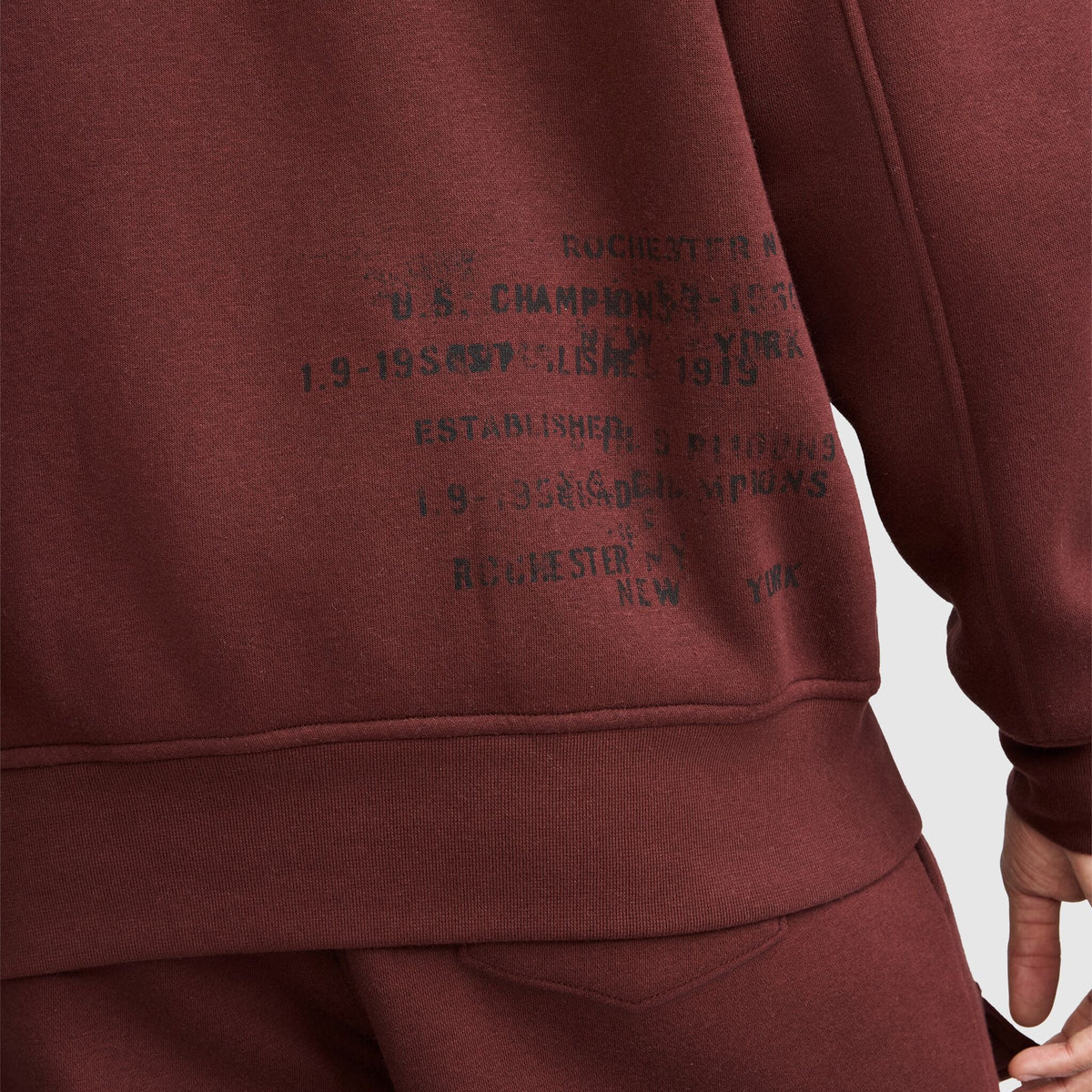 Champion fleece baseball jacket in dark red with distressed black text on the front reading Rochester New York and Established 1919.