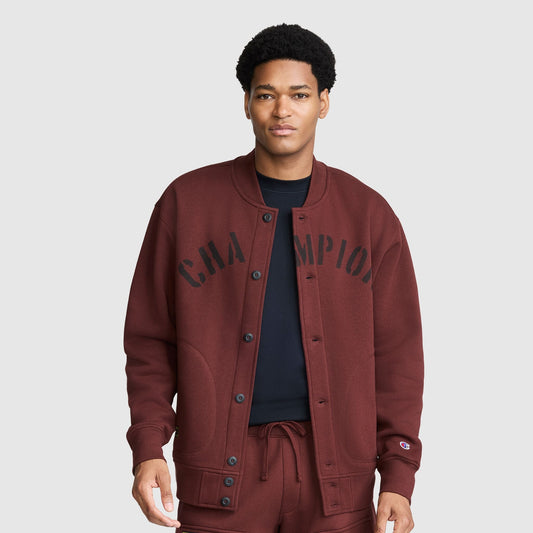 A person wearing a maroon Champion Fleece Baseball Jacket with black lettering across the chest.