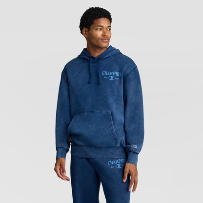 A man wearing a blue Mineral Wash Pullover Hoodie, C Patch Logo and matching sweatpants.