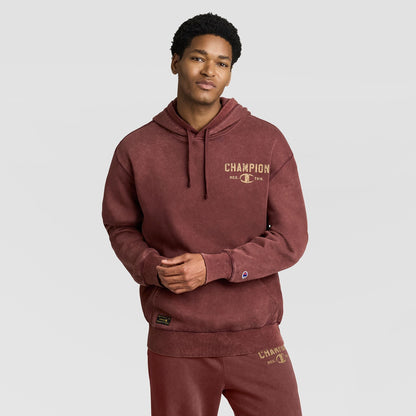 A person wearing a vintage maroon Mineral Wash Pullover Hoodie, C Patch Logo with a logo printed on the chest.